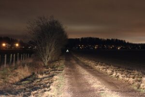 Pimeä pyöräily - pyörä auton ajovaloissa